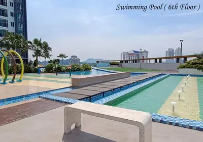 a swimming pool with a bench in front of it at Metropol Serviced Apartment Nice Pool View 3 BR in Bukit Mertajam