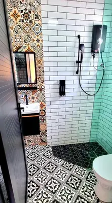 a bathroom with a shower with a sink and a mirror at Campod Resort @ Cameron Highlands in Cameron Highlands