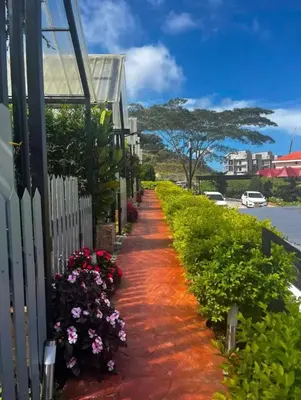 a pathway with flowers next to a house at Campod Resort @ Cameron Highlands in Cameron Highlands
