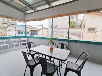 a table and chairs in a room with a balcony at Ipoh town centre glamping home 13pax in Ipoh