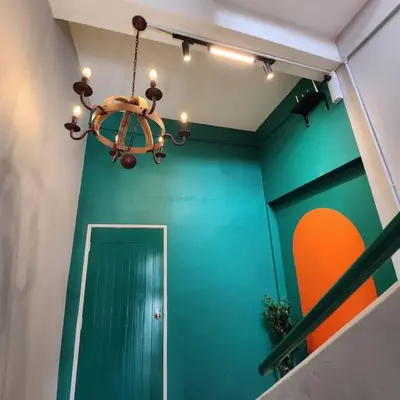 a room with a green wall and a chandelier at Ipoh town centre glamping home 13pax in Ipoh