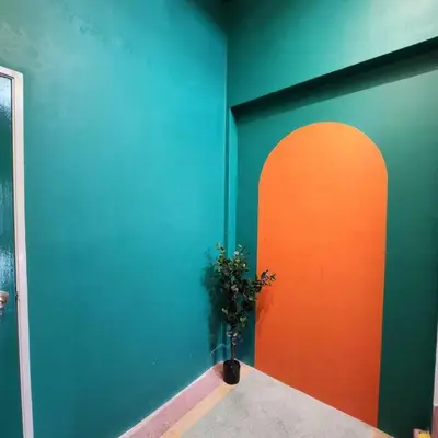 a blue and orange wall with a potted plant in a room at Ipoh town centre glamping home 13pax in Ipoh