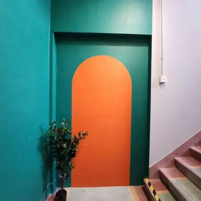 a door with an orange circle on the side of a building at ipoh town centre - nordic 7pax in Ipoh