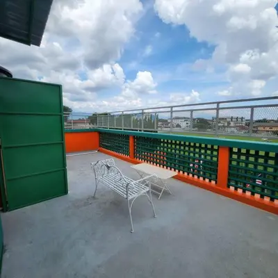 a white bench on a balcony with an orange and green railing at ipoh town centre - nordic 7pax in Ipoh
