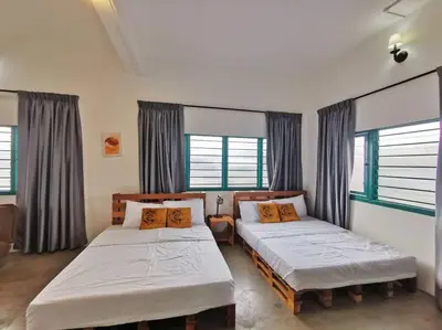 two beds in a room with two windows at Ipoh town centre -rustic home 4pax (studio 5) in Ipoh