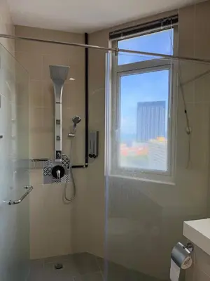 a bathroom with a glass shower with a window at 118 Apartment Tanjung Tokong by Yen's Sojourn in George Town
