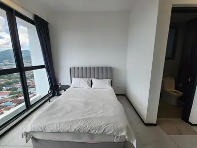 a bed in a room with a large window at Executive Urban Suites - George Town @ Penang in Jelutong