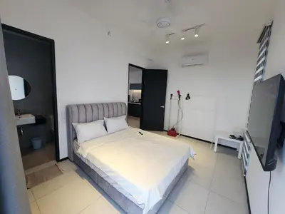 a bedroom with a bed and a flat screen tv at Executive Urban Suites - George Town @ Penang in Jelutong