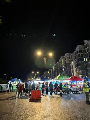 a group of people walking with umbrellas at night at Alliv NSF Studio & 1 Bedroom Apartment Stay in Brinchang