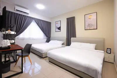 a hotel room with two beds and a desk at Brown Mansion CoLiving in George Town