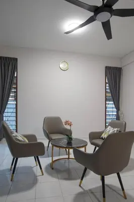 a living room with chairs and a table and a ceiling fan at Brown Mansion CoLiving in George Town