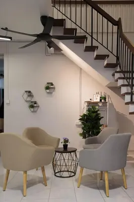 a living room with chairs and a staircase at Brown Mansion CoLiving in George Town