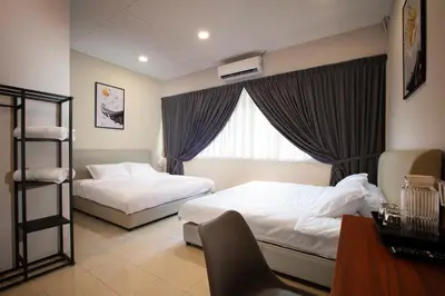 a hotel room with two beds and a window at Brown Mansion CoLiving in George Town