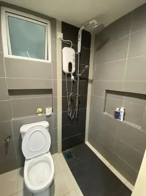 a bathroom with a toilet and a window and a shower at Champs Elysees Homestay by Landmark @ Kampar in Kampar