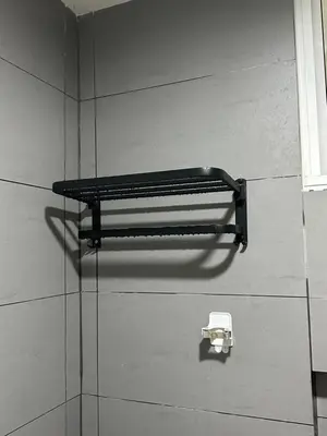 a black shelf on a wall with a toilet paper holder at Champs Elysees Homestay by Landmark @ Kampar in Kampar