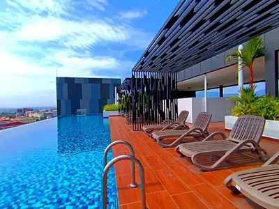 a row of chaise lounge chairs next to a swimming pool at The Horizon Ipoh 2BR L12 by Grab A Stay in Ipoh