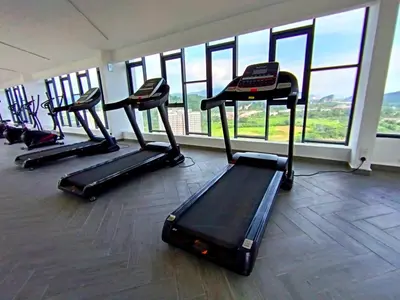 a gym with several treadmills in a room with windows at The Horizon Ipoh 2BR L12 by Grab A Stay in Ipoh