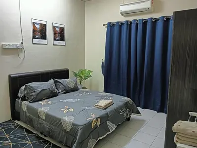 a bedroom with a bed and a blue curtain at Homestay Itqan Seri Iskandar in Seri Iskandar