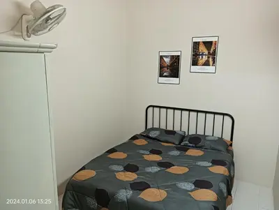 a bedroom with a bed with a comforter on it at Homestay Itqan Seri Iskandar in Seri Iskandar