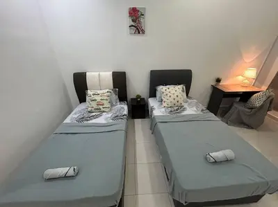 two twin beds in a room with a table at Cendana House Juru Autocity Bkt Minyak Batu Kawan IKEA in Simpang Ampat