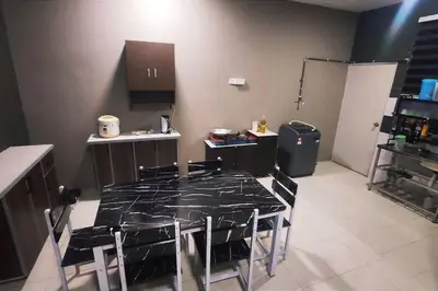 a kitchen with a table and chairs in it at Alysha Homestay in Kuala Lipis