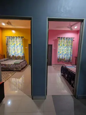 two beds in a room with two windows at Aish Homestay in Kuala Lipis