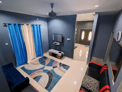 a living room with blue walls and blue curtains at Aish Homestay in Kuala Lipis