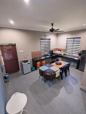 a kitchen with a table and chairs in a room at Aish Homestay in Kuala Lipis