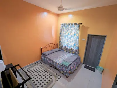 a small bed in a room with a curtain at Aish Homestay in Kuala Lipis