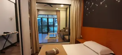 a room with a bed and a view of a living room at Cameron Square in Brinchang
