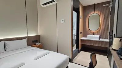 a bedroom with a bed and a sink and a mirror at Urban Inn, Serai Wangi in Padang Serai