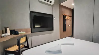 a room with a tv and a table and a chair at Urban Inn, Serai Wangi in Padang Serai