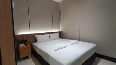 a bed with two pillows on it in a room at Urban Inn, Serai Wangi in Padang Serai