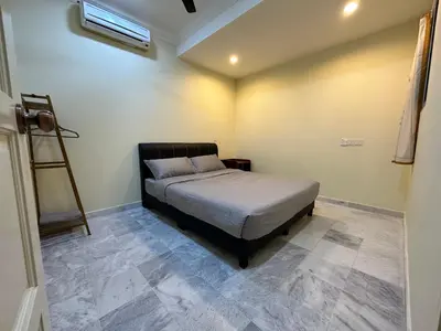 a bedroom with a bed in a room with a ladder at Claire Home Stay in Ipoh
