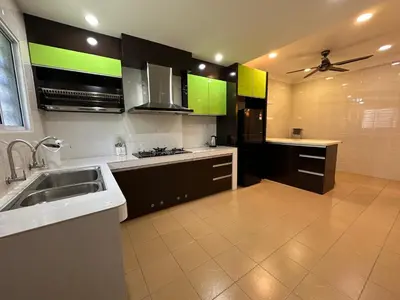 a kitchen with green and black cabinets and a sink at Claire Home Stay in Ipoh