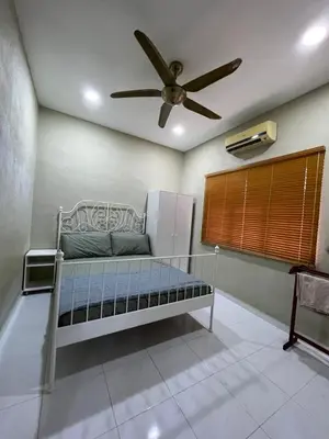 a bed in a room with a ceiling fan at Teratak LS Homestay in Kubang Semang