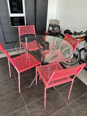 a glass table with four pink chairs and a glass table with a glass table at Pa&Ma HomeStay Kulim 4R3B fully aircond in Kulim