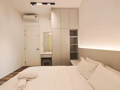a bedroom with a white bed and a mirror at Sunway Onsen Suites - Theme Park Tambun Ipoh by Ryokan Management in Tambun