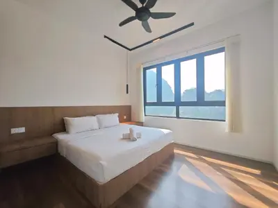 a bedroom with a large bed with a ceiling fan at Sunway Onsen Suites - Theme Park Tambun Ipoh by Ryokan Management in Tambun