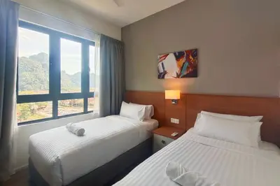 a hotel room with two beds and a window at Sunway Onsen Suites - Theme Park Tambun Ipoh by Ryokan Management in Tambun