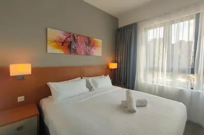 a hotel room with a large bed and a window at Sunway Onsen Suites - Theme Park Tambun Ipoh by Ryokan Management in Tambun