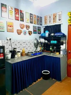 a kitchen with a table with a blue counter top at LH Alisha Homestay Bandar Utama Gua Musang in Gua Musang