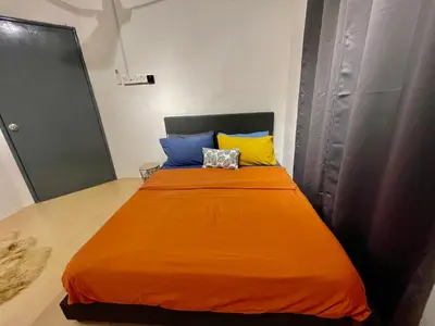 a bed with an orange blanket and colorful pillows at Cozy64#6pax#Netflix#NearAeonAlma#BM#5kmtoIconicPoint in Bukit Mertajam
