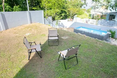 a group of chairs sitting on top of a yard at Beach side spacious 5BR 20pax pool house in Batu Ferringhi