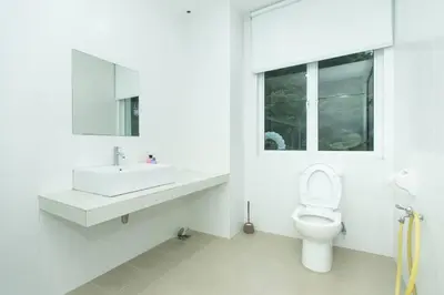 a white bathroom with a sink and a toilet at Beach side spacious 5BR 20pax pool house in Batu Ferringhi