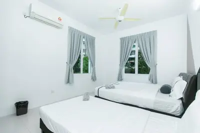 two beds in a white room with two windows at Beach side spacious 5BR 20pax pool house in Batu Ferringhi