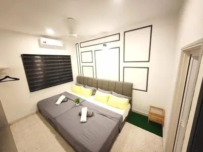 a bedroom with a large bed with yellow pillows at TL LEGEND HOMESTAY Ipoh garden east in Ipoh