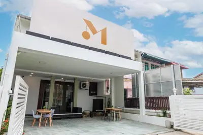 a white building with a sign on top of it at Momostay in George Town