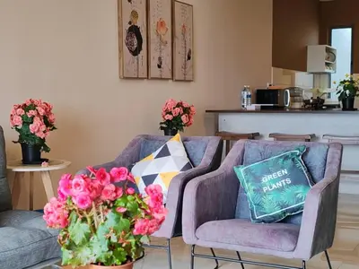 a living room with two couches and pink flowers at Kensington Sunrise sg, Palas Horizon,kea farm in Brinchang