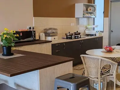 a kitchen with a counter and a table with chairs at Kensington Sunrise sg, Palas Horizon,kea farm in Brinchang